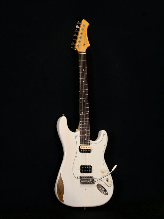 White electric guitar with a pickguard on a black background